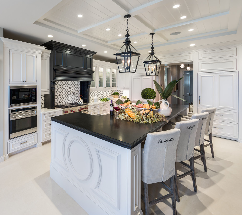 Eat-in kitchen - huge traditional l-shaped porcelain tile eat-in kitchen idea in Tampa with recessed-panel cabinets, white cabinets, solid surface countertops, multicolored backsplash, paneled appliances and an island