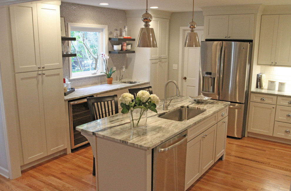 Inspiration for a timeless u-shaped light wood floor open concept kitchen remodel in Charleston with an undermount sink, white cabinets, granite countertops, white backsplash, subway tile backsplash, stainless steel appliances, shaker cabinets and an island