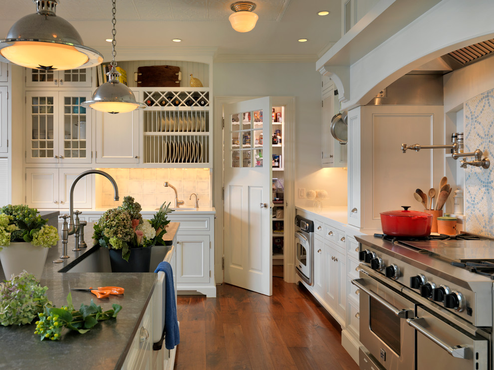 Klassische Küche mit Landhausspüle, Schrankfronten mit vertiefter Füllung, weißen Schränken, Küchenrückwand in Beige, Küchengeräten aus Edelstahl, Kücheninsel und dunklem Holzboden in Boston