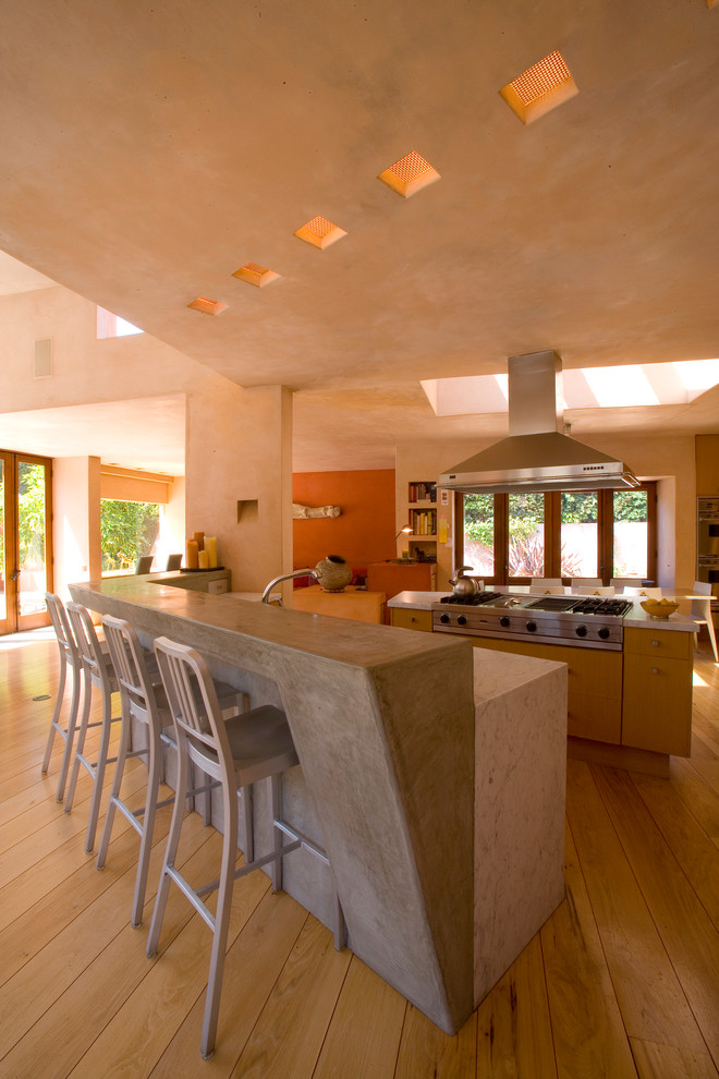 Eat-in kitchen - huge mediterranean galley light wood floor, beige floor and vaulted ceiling eat-in kitchen idea in Los Angeles with flat-panel cabinets, light wood cabinets, stainless steel appliances, an island and white countertops