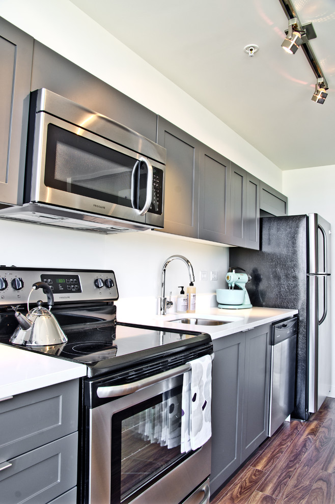 Diseño de cocina lineal contemporánea con fregadero de un seno, armarios con paneles empotrados y puertas de armario grises