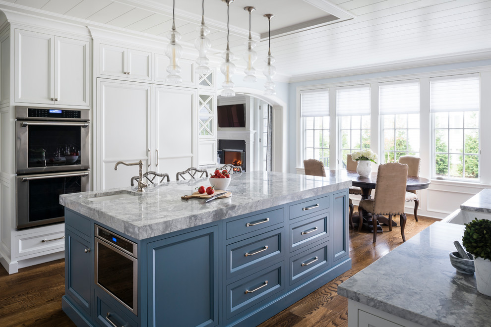 Foto di una cucina classica con lavello sottopiano, ante con riquadro incassato, ante blu, pavimento in legno massello medio, pavimento marrone e top multicolore