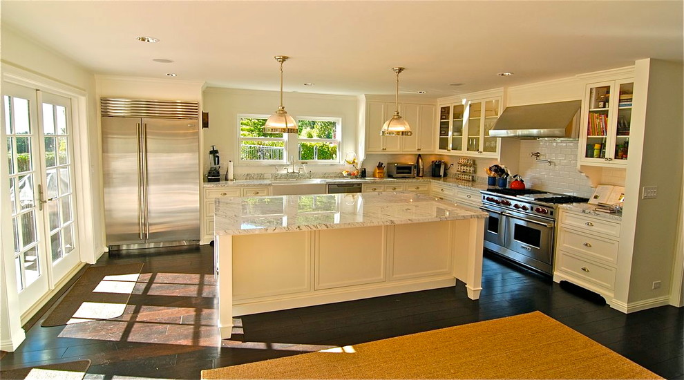Amerikansk inredning av ett kök och matrum, med en rustik diskho, skåp i shakerstil, vita skåp, marmorbänkskiva, vitt stänkskydd, stänkskydd i keramik och rostfria vitvaror