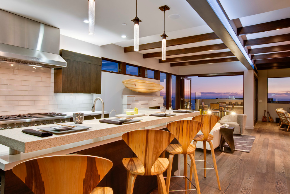 Inspiration for a coastal open concept kitchen remodel in Los Angeles with flat-panel cabinets, dark wood cabinets, white backsplash and subway tile backsplash
