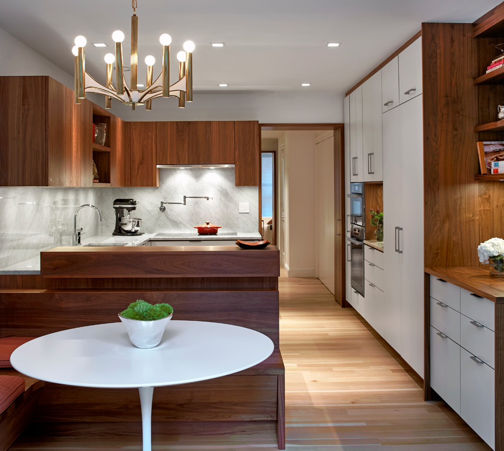 Idee per una cucina moderna con ante lisce, ante in legno bruno, paraspruzzi grigio, parquet chiaro e penisola