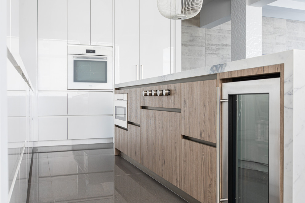 Ispirazione per una cucina minimal di medie dimensioni con lavello sottopiano, ante lisce, paraspruzzi bianco, pavimento in gres porcellanato, pavimento grigio e top bianco