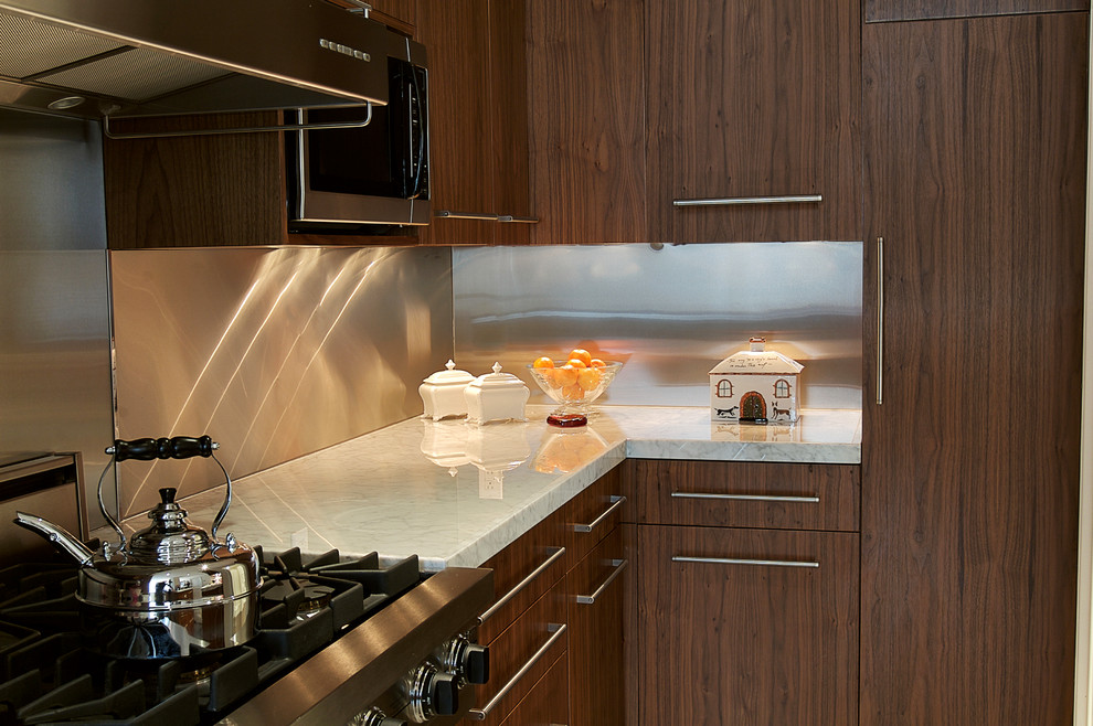 ニューヨークにあるトランジショナルスタイルのおしゃれなキッチン (フラットパネル扉のキャビネット、茶色いキャビネット、メタリックのキッチンパネル、メタルタイルのキッチンパネル、黒い調理設備) の写真