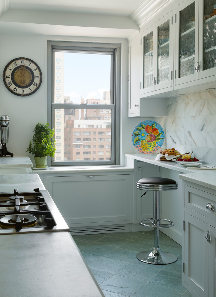 ニューヨークにある小さなトランジショナルスタイルのおしゃれなキッチン (ガラス扉のキャビネット、白いキャビネット、大理石カウンター、白いキッチンパネル、石タイルのキッチンパネル、スレートの床、アイランドなし) の写真