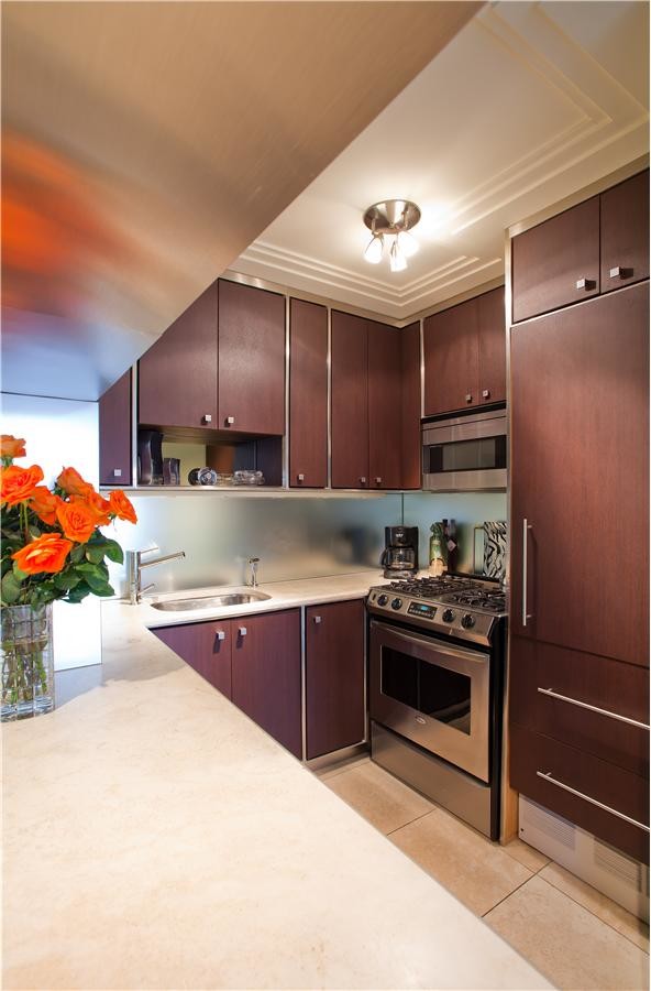 Design ideas for a small traditional u-shaped open plan kitchen in New York with a submerged sink, flat-panel cabinets, dark wood cabinets, soapstone worktops, glass sheet splashback, coloured appliances, ceramic flooring and a breakfast bar.