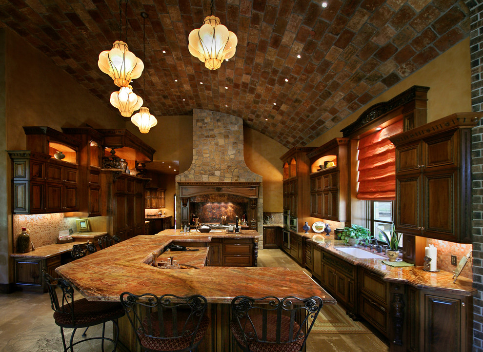 На фото: кухня в средиземноморском стиле с фартуком из плитки мозаики, врезной мойкой, фасадами с выступающей филенкой, темными деревянными фасадами, коричневым фартуком и техникой под мебельный фасад