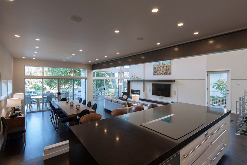 Inspiration for a large contemporary l-shaped dark wood floor eat-in kitchen remodel in Kansas City with an undermount sink, flat-panel cabinets, white cabinets, quartz countertops, white backsplash, glass sheet backsplash, stainless steel appliances and an island