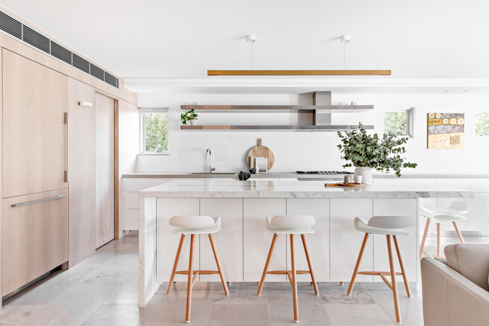 Moderne Küche in L-Form mit Unterbauwaschbecken, flächenbündigen Schrankfronten, weißen Schränken, Küchengeräten aus Edelstahl, Kücheninsel, grauem Boden und weißer Arbeitsplatte in Sydney