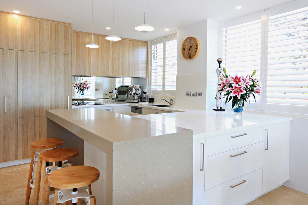 Design ideas for a small contemporary u-shaped kitchen/diner in Sydney with flat-panel cabinets, white cabinets, composite countertops, travertine flooring and a breakfast bar.