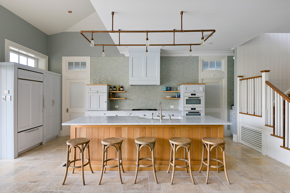 Kitchen - traditional l-shaped kitchen idea in Sydney with a farmhouse sink, recessed-panel cabinets, gray cabinets, gray backsplash, paneled appliances and an island