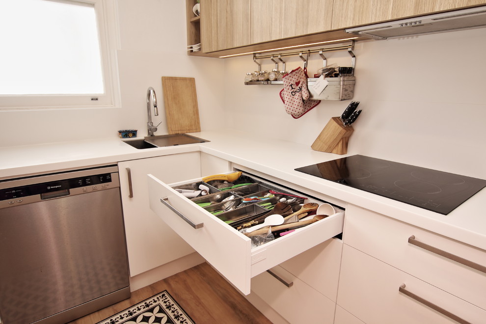 Maritim inredning av ett mellanstort kök, med en enkel diskho, släta luckor, vita skåp, bänkskiva i koppar, vitt stänkskydd, stänkskydd i keramik, rostfria vitvaror, vinylgolv, en halv köksö och brunt golv