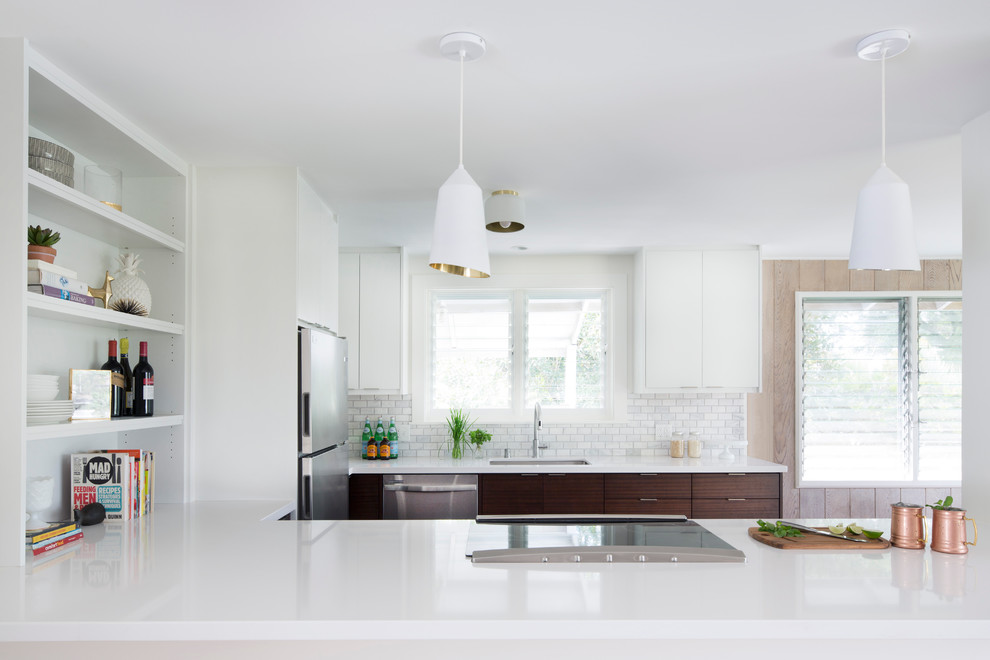 Exempel på ett eklektiskt u-kök, med en undermonterad diskho, släta luckor, vita skåp, bänkskiva i kvarts, grått stänkskydd, stänkskydd i stenkakel, rostfria vitvaror, klinkergolv i porslin och en halv köksö