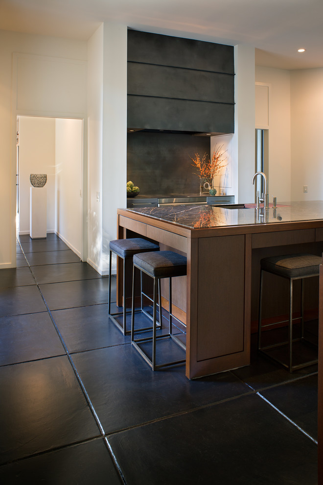 Modern inredning av ett mellanstort kök, med en nedsänkt diskho, granitbänkskiva, svart stänkskydd, stänkskydd i metallkakel, rostfria vitvaror, klinkergolv i keramik, en köksö och svart golv