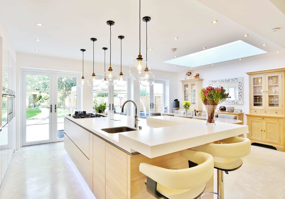 Immagine di un cucina con isola centrale design di medie dimensioni con lavello sottopiano, ante lisce, ante in legno chiaro, pavimento in linoleum e pavimento grigio