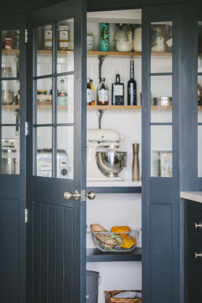 Imagen de cocina de estilo de casa de campo grande con fregadero encastrado, armarios estilo shaker, puertas de armario azules, encimera de cuarzo compacto, electrodomésticos de acero inoxidable, suelo de piedra caliza, una isla y encimeras grises