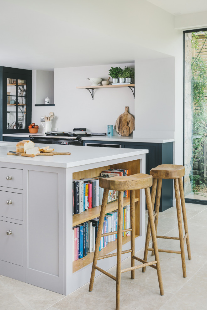 Foto på ett stort lantligt grå kök, med en nedsänkt diskho, skåp i shakerstil, blå skåp, bänkskiva i kvarts, rostfria vitvaror, kalkstensgolv och en köksö