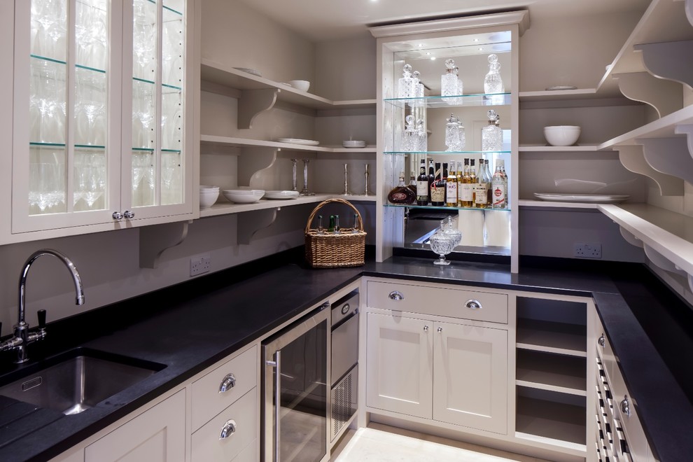Diseño de cocina comedor clásica renovada con fregadero bajoencimera, armarios con paneles lisos, puertas de armario blancas y electrodomésticos de acero inoxidable