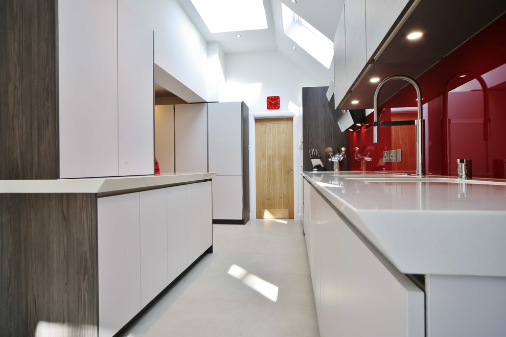 Inspiration for a large contemporary galley open concept kitchen remodel in London with flat-panel cabinets, medium tone wood cabinets, quartzite countertops, red backsplash, glass sheet backsplash, stainless steel appliances and a peninsula