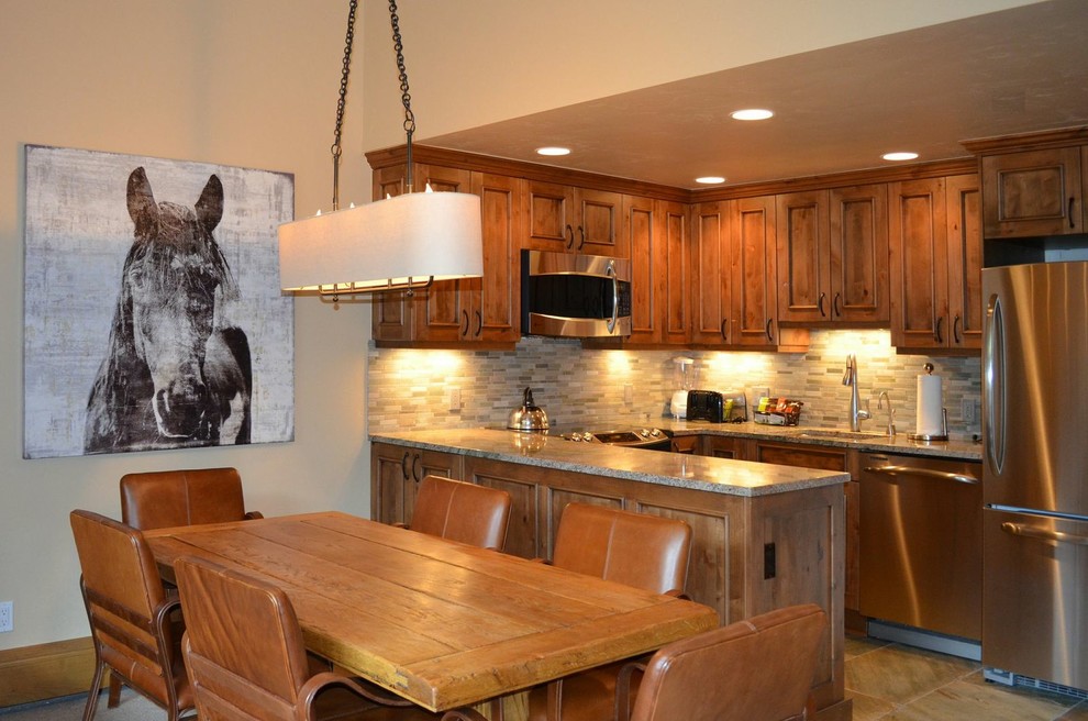 Inspiration for a mid-sized rustic u-shaped eat-in kitchen remodel in Denver with an undermount sink, raised-panel cabinets, medium tone wood cabinets, granite countertops, green backsplash, stone tile backsplash, stainless steel appliances and no island