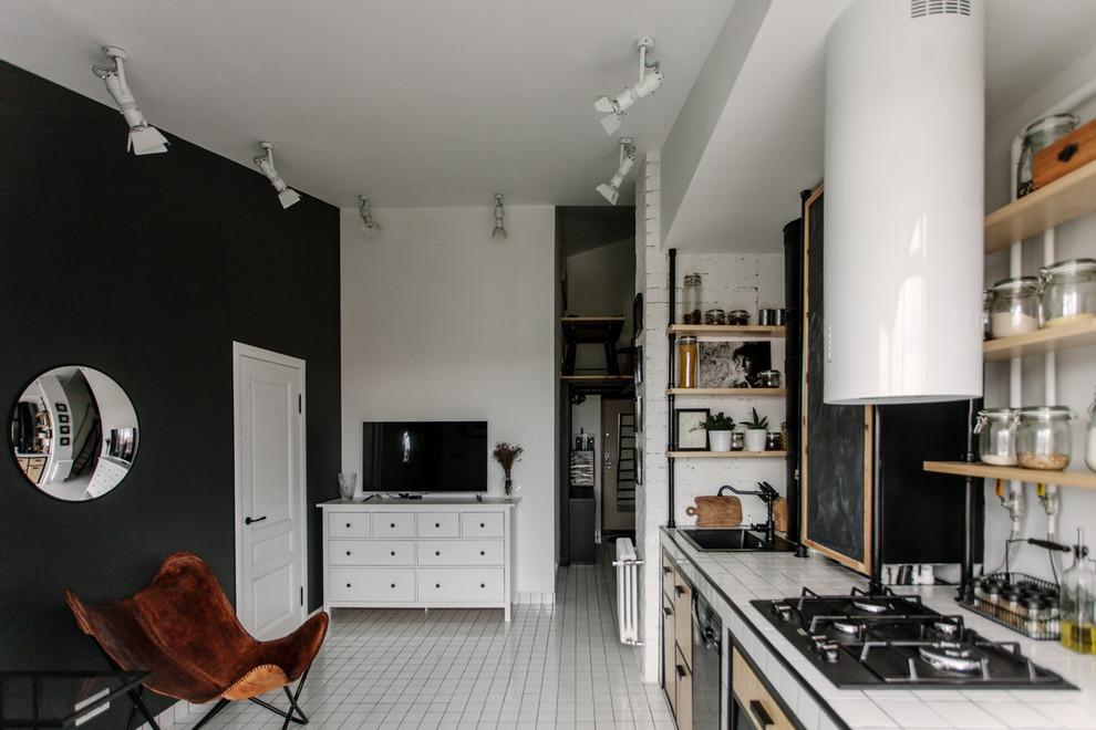 Industriell inredning av ett litet linjärt kök med öppen planlösning, med en undermonterad diskho, kaklad bänkskiva och vitt golv