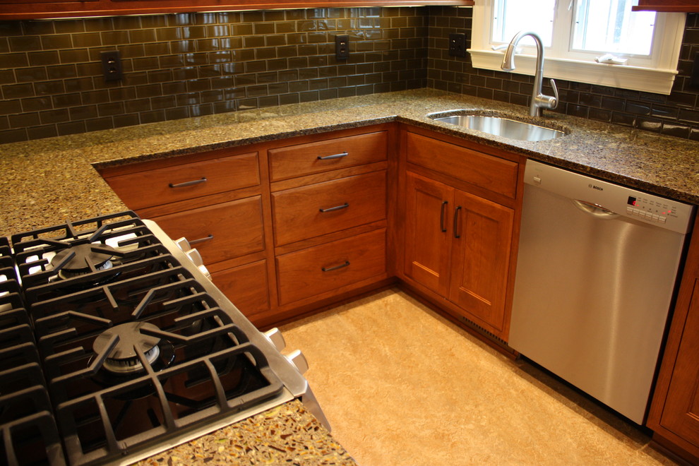 Exempel på ett avskilt, litet eklektiskt u-kök, med en undermonterad diskho, släta luckor, skåp i mellenmörkt trä, bänkskiva i återvunnet glas, grönt stänkskydd, stänkskydd i glaskakel, rostfria vitvaror, linoleumgolv och gult golv