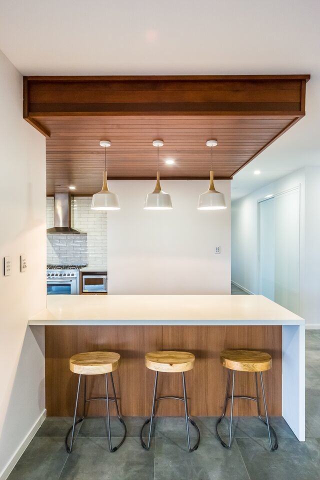 Photo of a large contemporary u-shaped kitchen/diner in Brisbane with a double-bowl sink, flat-panel cabinets, medium wood cabinets, white splashback, ceramic splashback, stainless steel appliances and an island.