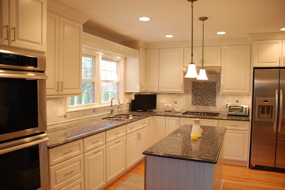 Large transitional l-shaped medium tone wood floor eat-in kitchen photo in Chicago with an undermount sink, raised-panel cabinets, white cabinets, granite countertops, stainless steel appliances and an island