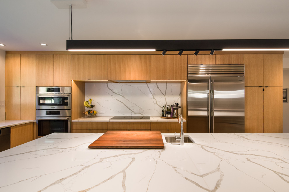 Photo of a large modern l-shaped enclosed kitchen in Chicago with flat-panel cabinets, light wood cabinets, marble worktops, white splashback, stone slab splashback, stainless steel appliances, porcelain flooring, an island, grey floors and white worktops.