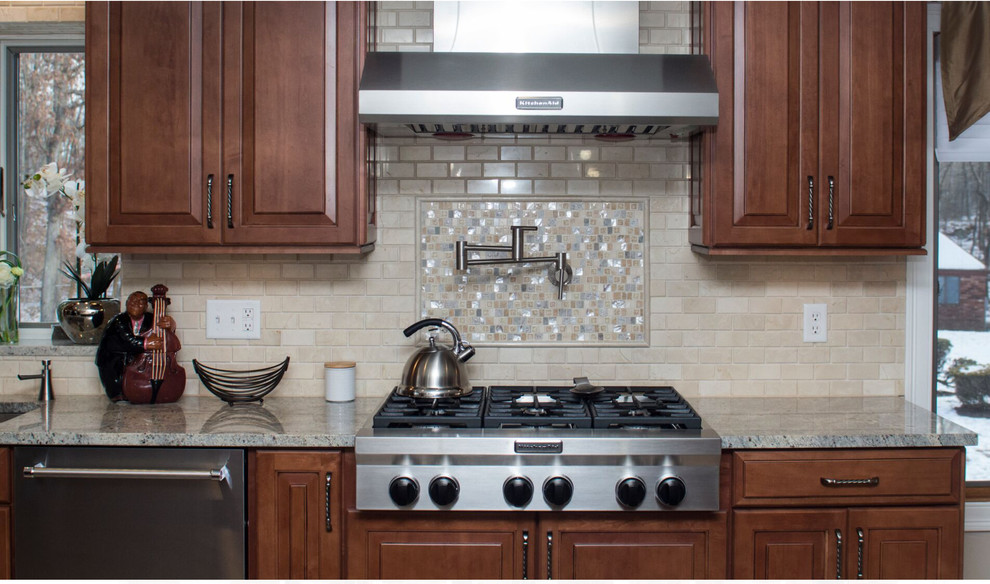 Example of a huge classic l-shaped porcelain tile eat-in kitchen design in Providence with an undermount sink, raised-panel cabinets, dark wood cabinets, granite countertops, beige backsplash, stone tile backsplash, stainless steel appliances and an island