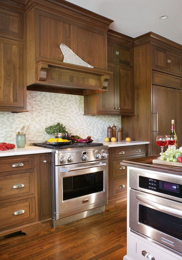 Exemple d'une cuisine encastrable tendance en bois brun avec un placard à porte shaker et une crédence blanche.