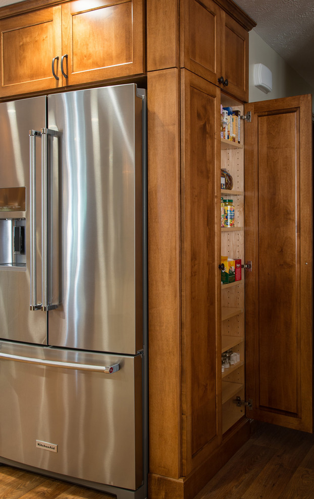 Cette photo montre une cuisine chic avec un placard à porte shaker, un plan de travail en granite, une crédence verte, un électroménager en acier inoxydable et îlot.