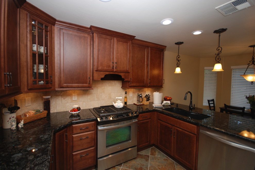 Small classic u-shaped enclosed kitchen in Other with a submerged sink, recessed-panel cabinets, medium wood cabinets, granite worktops, beige splashback, stone tiled splashback, stainless steel appliances and slate flooring.