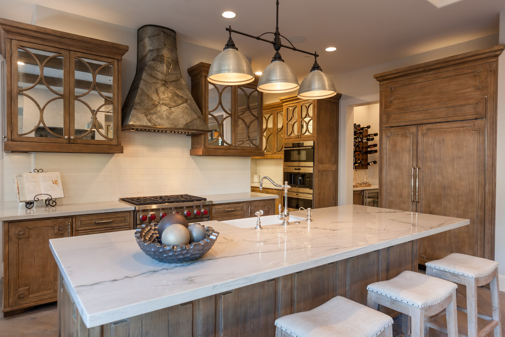 Exempel på ett mycket stort klassiskt vit linjärt vitt kök med öppen planlösning, med en rustik diskho, luckor med glaspanel, skåp i mellenmörkt trä, vitt stänkskydd, stänkskydd i tunnelbanekakel, rostfria vitvaror, mellanmörkt trägolv, en köksö och brunt golv