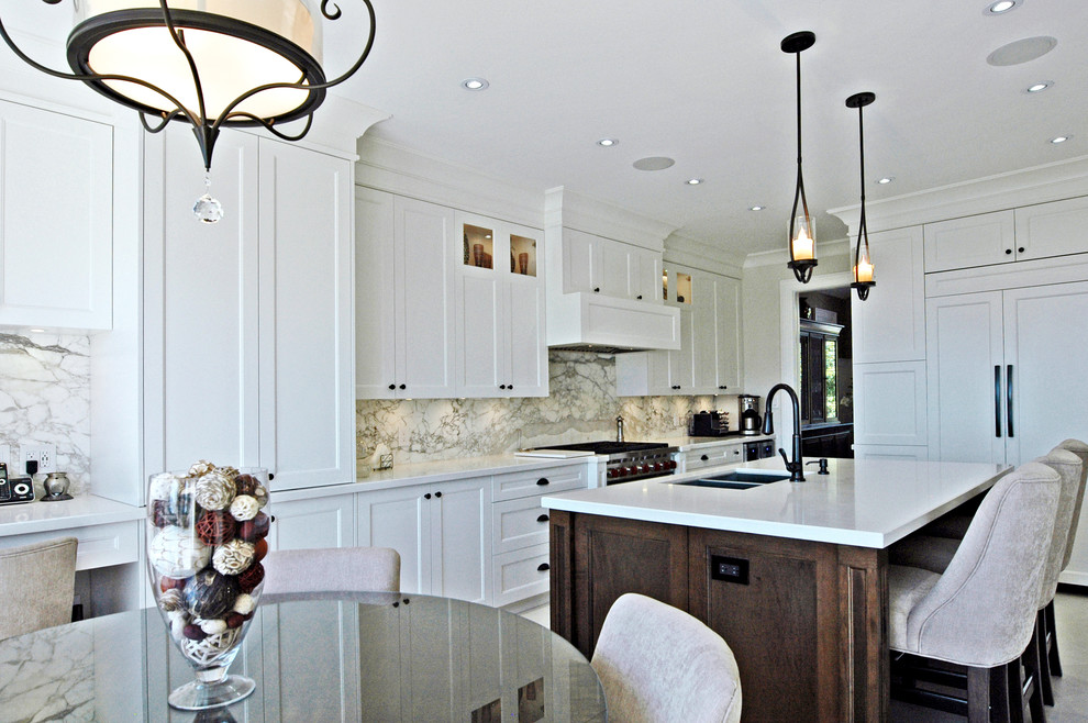 Large transitional u-shaped eat-in kitchen photo in Toronto with a double-bowl sink, shaker cabinets, white cabinets, gray backsplash, stainless steel appliances and an island