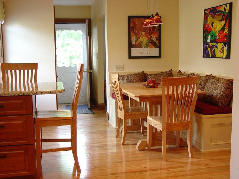 Immagine di una sala da pranzo aperta verso la cucina tradizionale di medie dimensioni con pavimento in legno massello medio