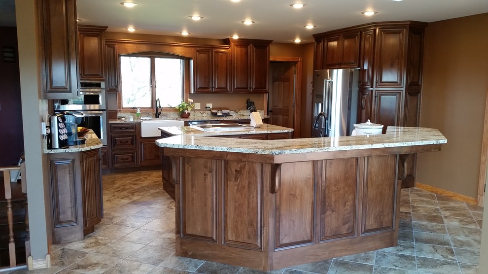 Large elegant u-shaped ceramic tile kitchen photo in Other with a farmhouse sink, raised-panel cabinets, medium tone wood cabinets, granite countertops, stainless steel appliances and two islands
