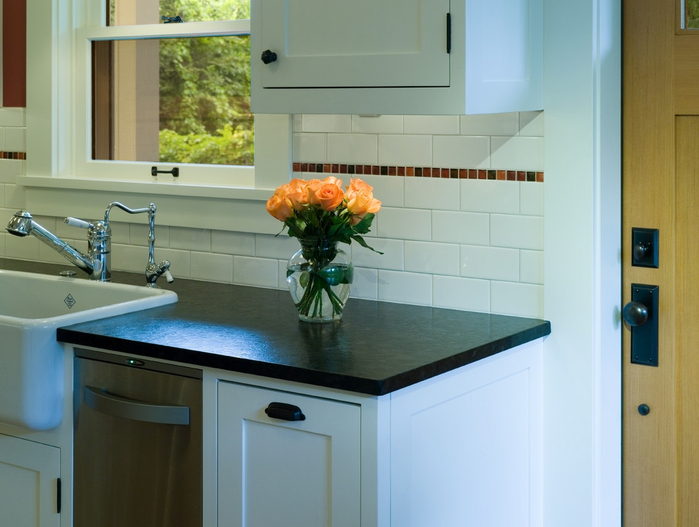 Urige Küche mit Landhausspüle, weißen Schränken, Küchenrückwand in Weiß, Rückwand aus Metrofliesen und Küchengeräten aus Edelstahl in Seattle