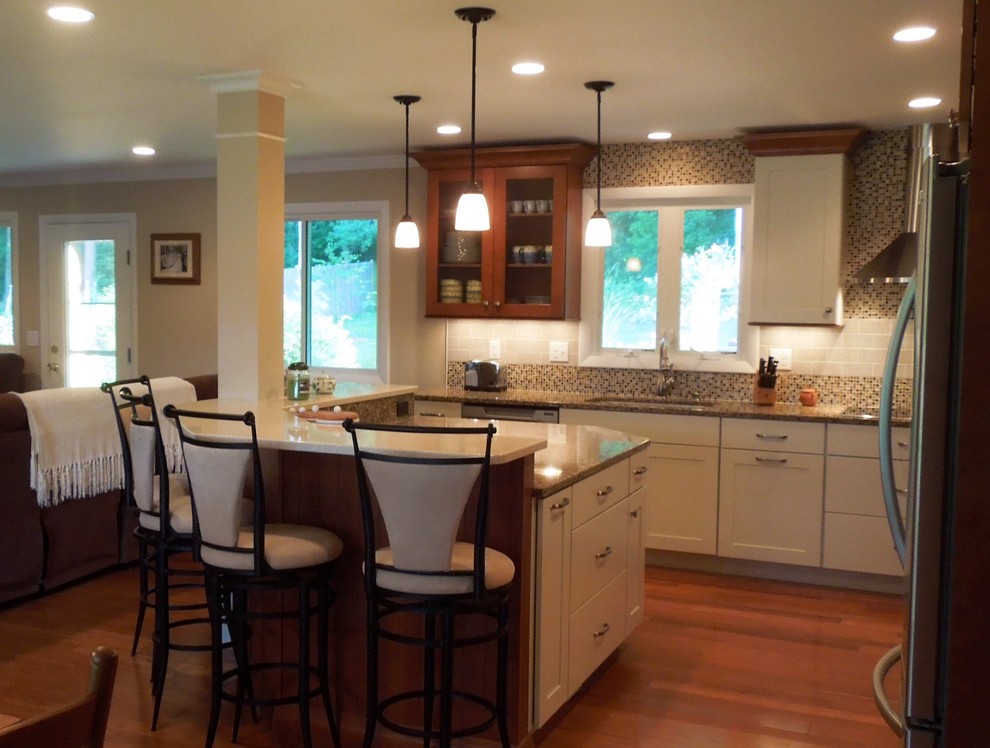 Example of a classic open concept kitchen design in Manchester with a single-bowl sink, glass-front cabinets, white cabinets, quartz countertops, multicolored backsplash and stainless steel appliances