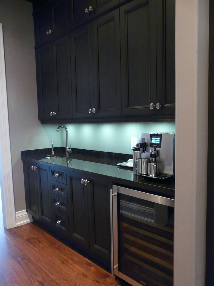 This is an example of a traditional single-wall kitchen/diner in Toronto with a submerged sink, recessed-panel cabinets, dark wood cabinets, granite worktops and stainless steel appliances.