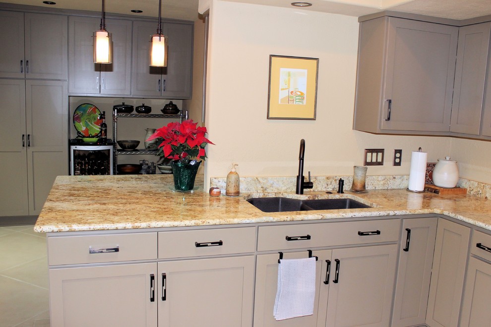 Example of a large classic l-shaped linoleum floor enclosed kitchen design in Phoenix with an undermount sink, recessed-panel cabinets, beige cabinets, granite countertops, beige backsplash, stone slab backsplash, stainless steel appliances and a peninsula