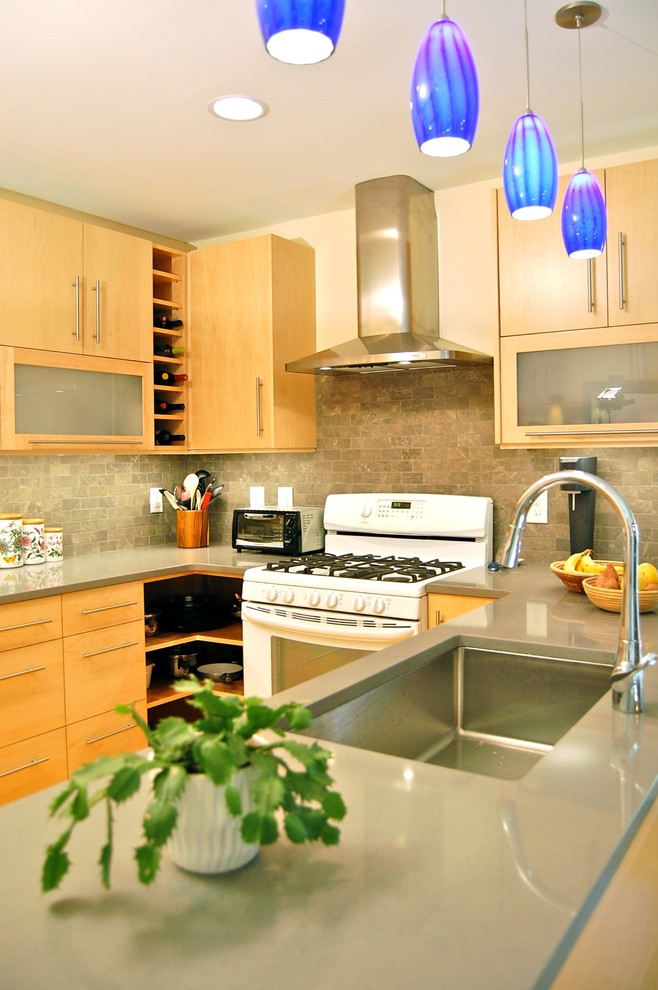 Foto på ett funkis kök, med en nedsänkt diskho, släta luckor, skåp i mellenmörkt trä, grått stänkskydd, stänkskydd i stenkakel, rostfria vitvaror och mellanmörkt trägolv