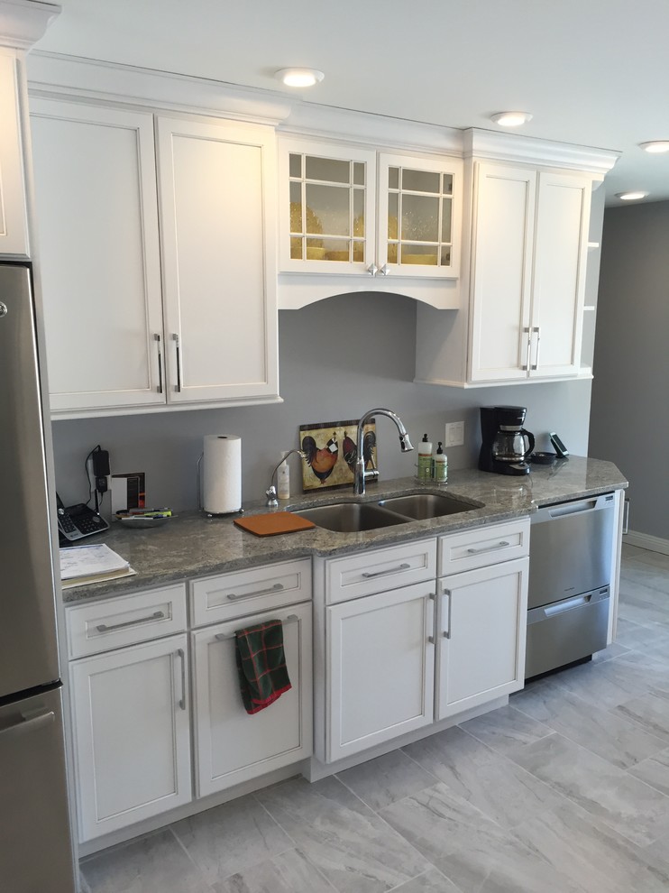 This is an example of a large traditional l-shaped kitchen/diner in Other with a submerged sink, shaker cabinets, white cabinets, granite worktops, stainless steel appliances, porcelain flooring, no island and grey floors.