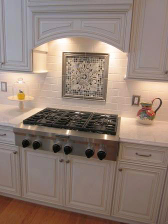 Example of a classic u-shaped eat-in kitchen design in Chicago with a single-bowl sink, raised-panel cabinets, white cabinets, white backsplash, ceramic backsplash and stainless steel appliances