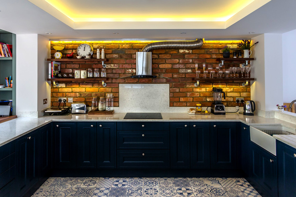 Inspiration för mellanstora eklektiska linjära kök med öppen planlösning, med en rustik diskho, skåp i shakerstil, blå skåp, bänkskiva i kvartsit, rött stänkskydd, stänkskydd i tegel, svarta vitvaror, klinkergolv i keramik, en halv köksö och blått golv