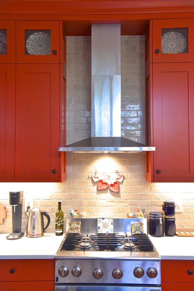 デンバーにあるお手頃価格の中くらいなトランジショナルスタイルのおしゃれなキッチン (アンダーカウンターシンク、シェーカースタイル扉のキャビネット、赤いキャビネット、ソープストーンカウンター、ベージュキッチンパネル、レンガのキッチンパネル、シルバーの調理設備、淡色無垢フローリング、茶色い床) の写真