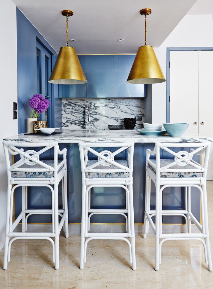 На фото: кухня в современном стиле с синими фасадами, мраморной столешницей, фартуком из каменной плитки и полуостровом с